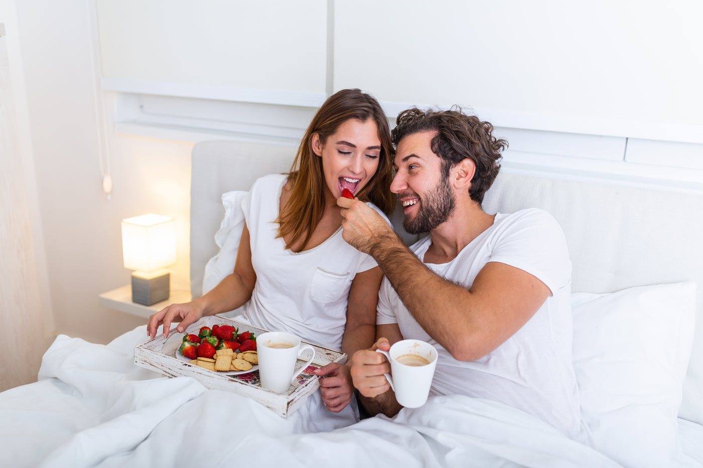 Man feeding his wife on bed