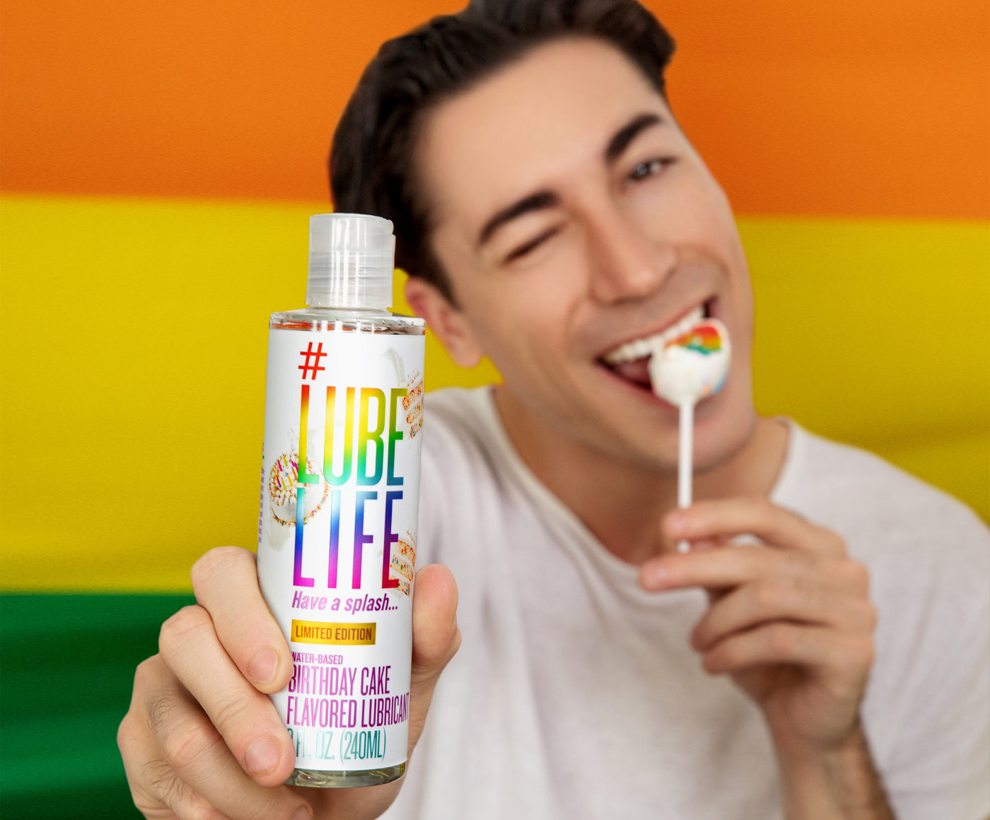Man eating candy and holding lubelife in background pride Flag